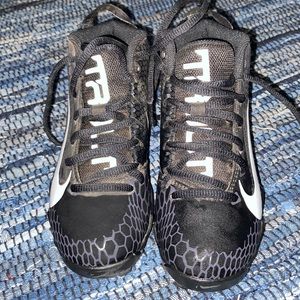 Selling a pair of size 1 boys Nike cleats. They are white and black in color.